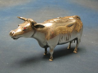 A Victorian Continental silver cow creamer in the form of a standing horned cow with hinged lid, having Continental marks and London import marks for 1891, the eyes set red hard stones, 9 ozs (ear f) (NB - a gift to the vendor's Father by the Guinness family)