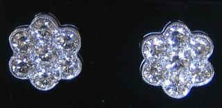 A pair of lady's floral cluster design diamond set earrings, each set 7 diamonds (approx 2.07ct)