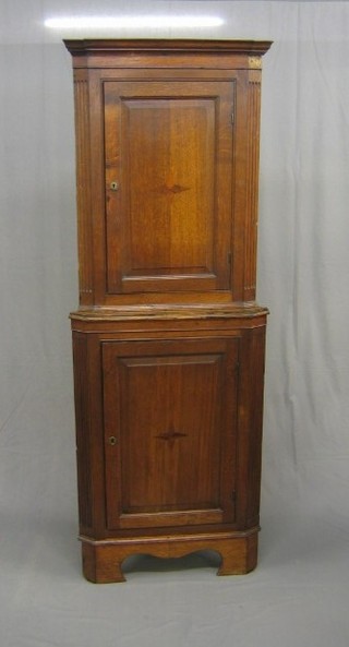 An 18th Century oak double corner cabinet, the upper section with moulded cornice, shelved interior enclosed by a panelled door with fluted columns to the sides, the base the same and raised on bracket feet 28"