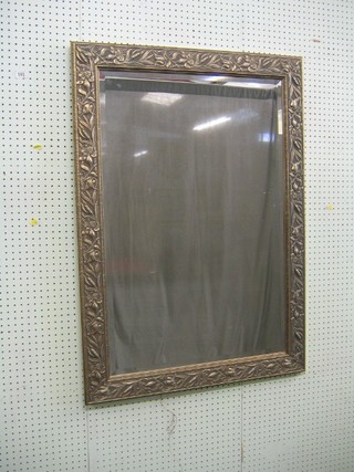 A rectangular bevelled plate wall mirror contained in a silvered Art Nouveau style frame 42"