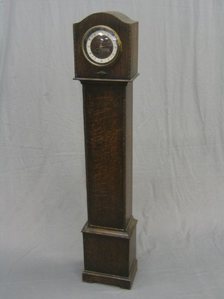 A 1930's oak granddaughter clock case containing a striking French movement, contained in an oak arch shaped case 53"