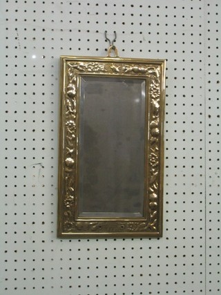 A rectangular bevelled plate mirror contained in an embossed brass frame 15"