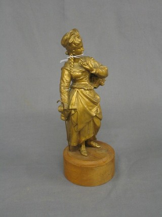 A gilt painted spelter figure of a standing shepherdess  raised on a turned oak base 12"