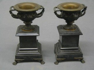 A handsome pair of Victorian bronze twin handled urns decorated classical figures, raised on black marble bases 12"