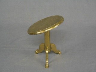 A circular brass trivet in the form of a snap top pedestal table 6"