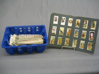 A collection of cigarette cards, tea cards and foreign coins