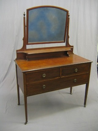 An Edwardian inlaid mahogany dressing table with arch shaped mirror over, the base fitted 2 short drawers above 1 long drawer, raised on square tapering supports ending in brass caps and castors 42"