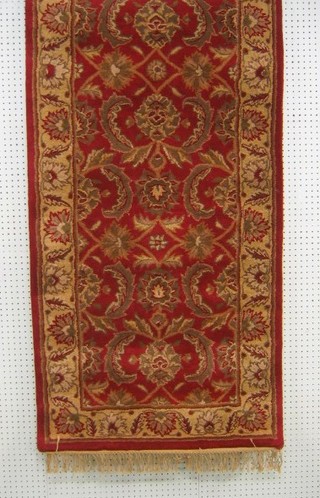 A contemporary red and gold ground Ziegler runner 96" x 32"