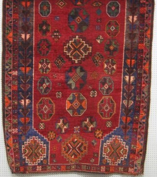 A contemporary red ground Persian carpet with octagons to the centre 84" x 53"