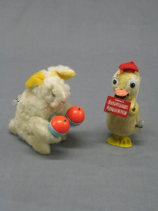 A 1960's plastic and tin plate clock work figure of a conductor duck, the base marked Made in Japan and 1 other rabbit with pair of castanets