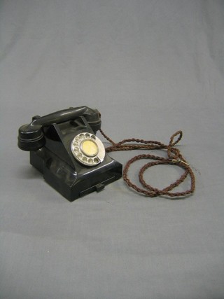 An old black Bakelite dial telephone, the base marked E2 GPO batch sampled 668