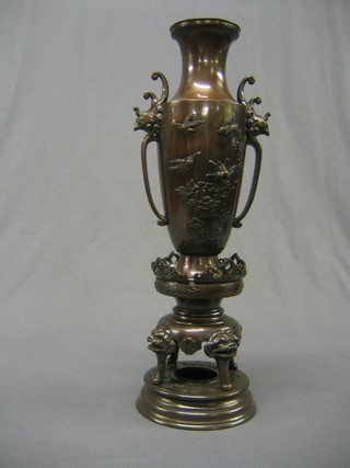 A large and impressive Oriental bronze twin handled vase, raised on a circular base and decorated dogs of fo, 23"