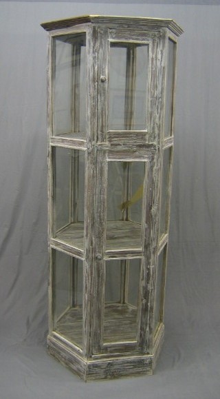 An Eastern limed hardwood free standing octagonal display cabinet, enclosed by glazed panelled doors 30"