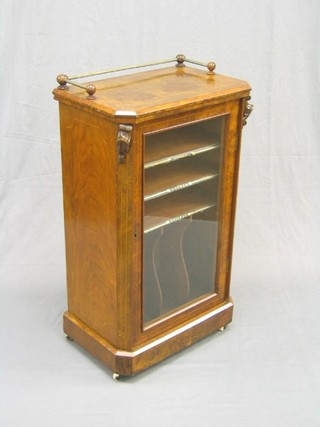 A Victorian inlaid and figured walnut music cabinet, the upper section with brass railed gallery, the interior fitted shelves enclosed by a glazed panelled door 22"