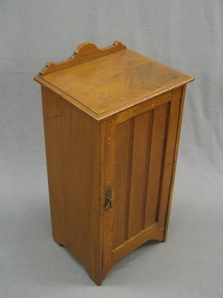 An Edwardian pine bedside cabinet enclosed by panelled doors  16"