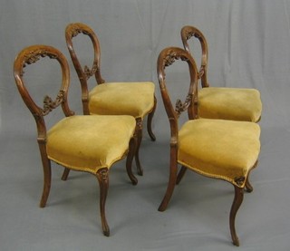 A set of 4 Victorian carved walnut balloon back dining chairs with pierced mid rails, the seats of serpentine outline, raised on French supports