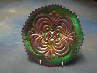 A circular purple Carnival glass dish with stylised decoration 9"