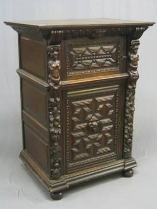 A 19th Century Continental carved oak cabinet, the upper section fitted a cupboard enclosed by a panelled door, the base fitted a cupboard enclosed by a panelled door, flanked by a pair of columns, the capitals in the form of figures 35"