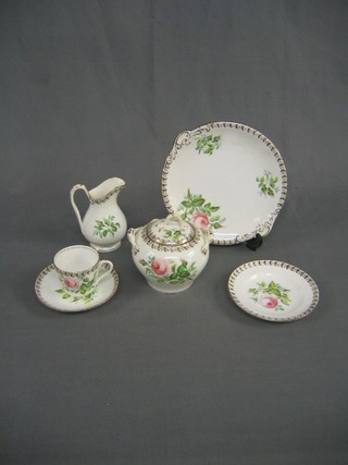 A floral pattern tea service with rose decoration, comprising 2 twin handled bread plates, lidded sucrier, cream jug, 11 tea plates (2 cracked), 12 saucers (1 cracked) 5 cups (1 cracked), some rubbing to banding