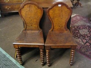 A pair of Victorian Pollard oak hall chairs raised on spiral turned supports