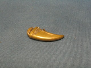 An Edwardian brass vesta case in the form of a tigers tooth, the finial in the form of a walking pig