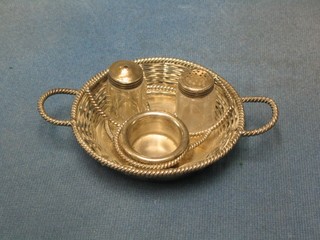 A circular basket work silver plated condiment frame with salt, pepper and mustard pot