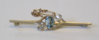 A lady's attractive 9ct gold bar brooch set an oval aquamarine supported by diamonds