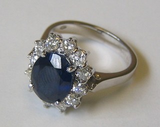 A lady's attractive 18ct white gold dress ring set an oval cut sapphire (approx 3.6ct) surrounded by 12 diamonds