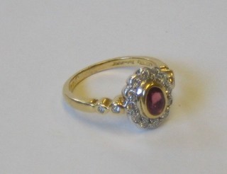A lady's 18ct gold dress ring set an oval ruby surrounded by diamonds