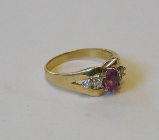 A lady's 18ct yellow gold dress ring set an oval cut pink sapphire supported by 4 diamonds