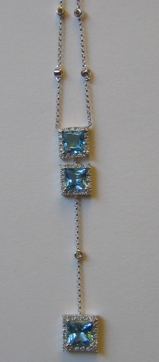 A lady's attractive 18ct white gold bracelet set 3 square blue cut topaz surrounded by diamonds