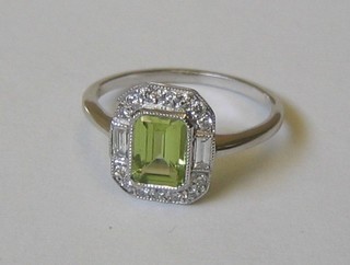 A lady's 18ct white gold dress ring set a rectangular cut peridot supported by 2 baguette cut diamonds and numerous other diamonds