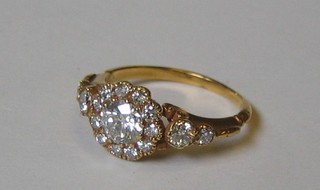 A lady's attractive 18ct yellow gold cluster dress ring set a large central diamond supported by 7 diamonds and with 4 diamonds to the shoulders (approx 1.13ct)
