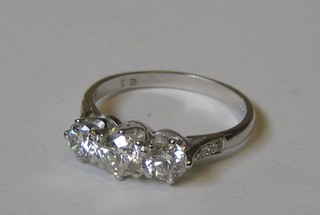 A lady's attractive 18ct white gold 3 stone diamond dress ring supported by 6 diamonds to the shoulders (in all 1.21ct)