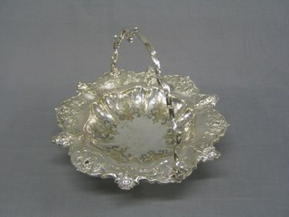 A 19th Century circular engraved and embossed silver plated cake basket with swing handle