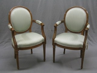A pair of 20th Century Adam style walnut open arm chairs, raised on turned and reeded supports