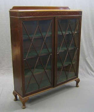 An Edwardian inlaid mahogany bookcase fitted adjustable shelves enclosed by astragal glazed doors, raised on cabriole supports 43"