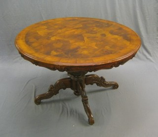 A 20th Century Victorian style circular pedestal table with figured walnut top, raised on a carved column and tripod base 47"