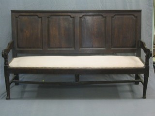 An 18th Century oak settle with panel back and upholstered seated seat raised on turned supports with H framed stretcher (some worm to legs and old repair to stretcher) 73 1/2"