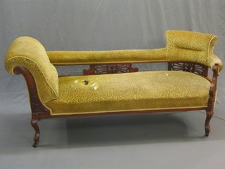 An Edwardian carved walnut show frame chaise longue upholstered in yellow material, on cabriole supports (holes to seat)