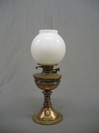 An Art Nouveau brassed copper oil lamp reservoir complete with chimney and white glass shade
