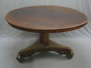A William IV oval mahogany breakfast table, with gadrooned border and raised on a turned and triform base with scroll feet (table top reduced in diameter) 54"