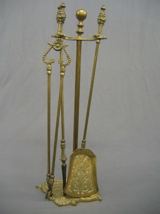A reproduction 19th Century brass fire side companion set with stand, tongs, shovel and poker