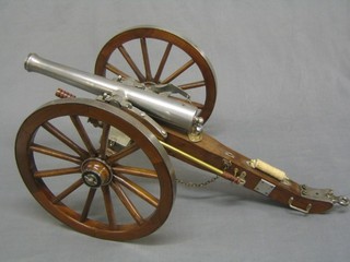 A 20th Century polished steel and mahogany model field gun with 50" steel barrel, raised on a mahogany and steel carriage