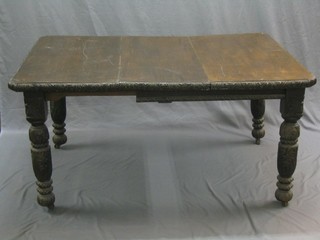 A Victorian carved oak extending dining table, raised on turned supports with 2 extra leaves