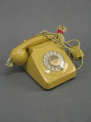 An old plastic yellow dial telephone