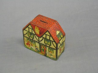 A Lanes & Co biscuit tin money box in the form of a cottage with Mad Hatter tea party in progress