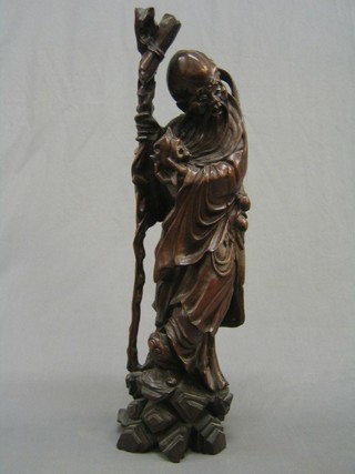 An Oriental carved rootwood figure of a standing sage with hardstone set eyes 26" crack to centre    
