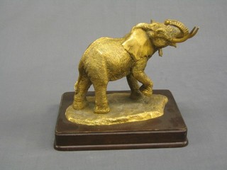 A gilt bronze figure of a standing elephant by Anthony J Jones together with a 1979 Golden Elephant Proof One Hundred Dollar Gold Coin of Liberia