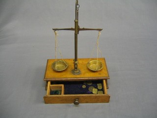 A pair of 19th Century brass and iron  scales, raised on a wooden base with various weights